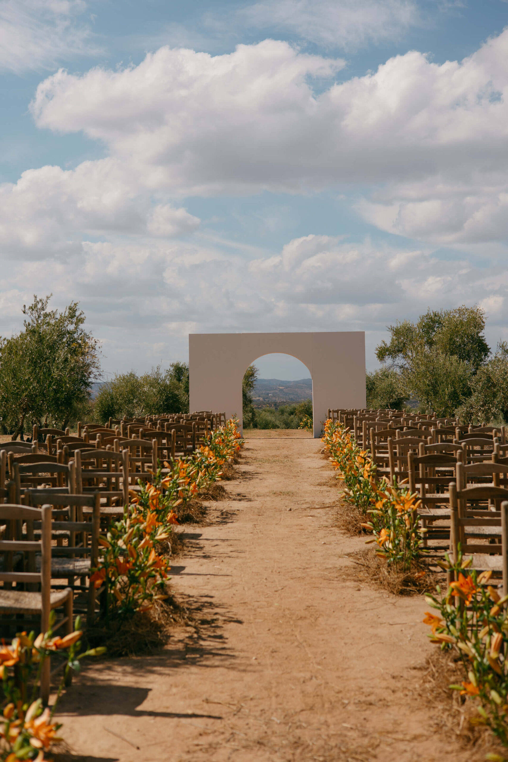 Ceremonia de boda al aire libre con pasillo de flores naranjas